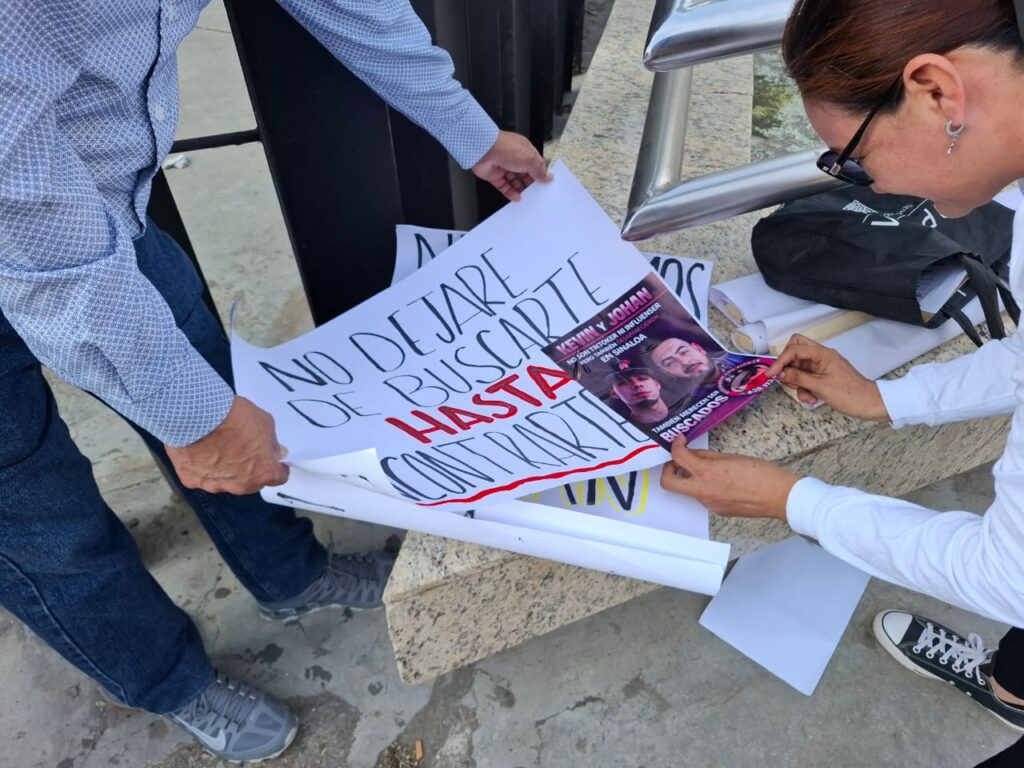 Familiares de desaparecidos arman cartulinas en marcha