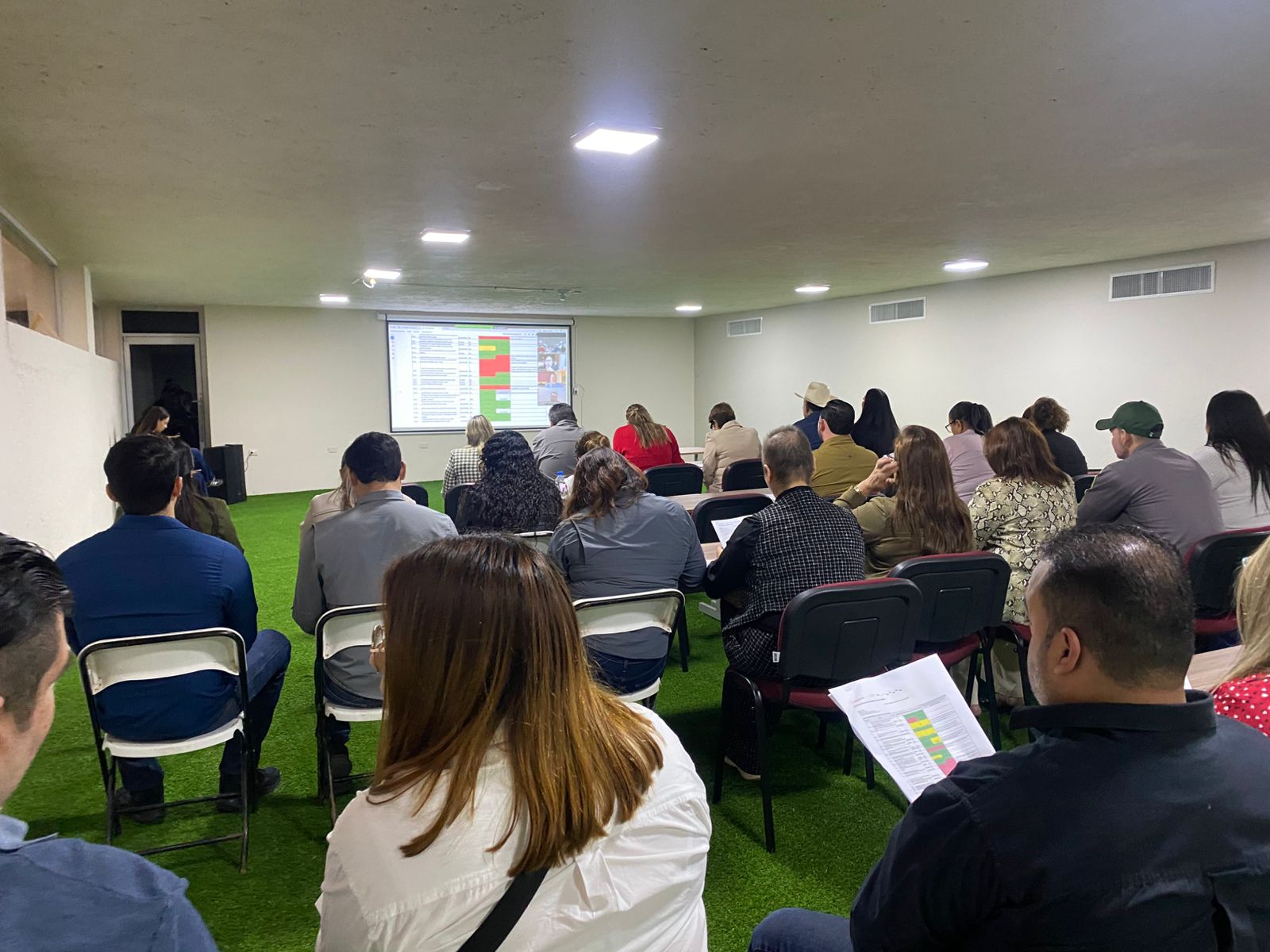 Personas en una sala durante una reunión sentadas