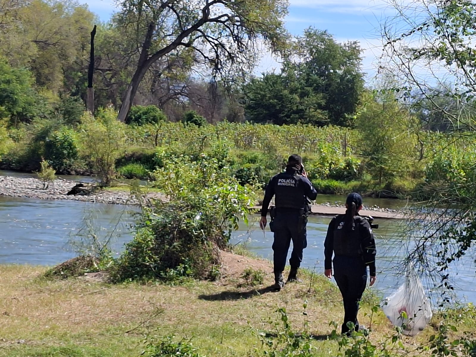 Policía Municipal en el río Sinaloa tras el hallazgo del cuerpo del adolescente.