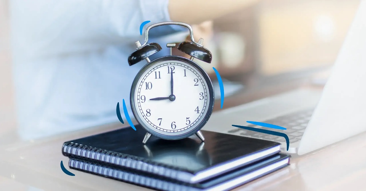 Reloj encima de unos cuadernos.