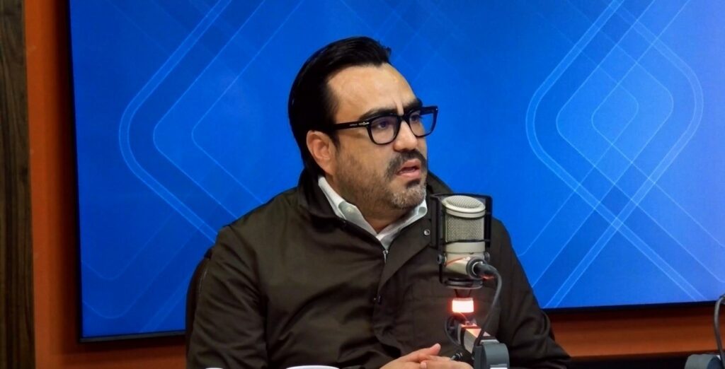 Juan de Dios Gámez Mendívil, alcalde de Culiacán, en un estudio de grabación con un micrófono frente a él