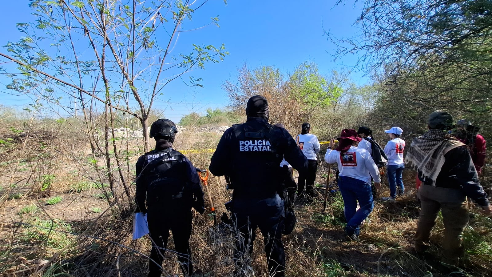 Policía estatal y buscadores en terreno baldío