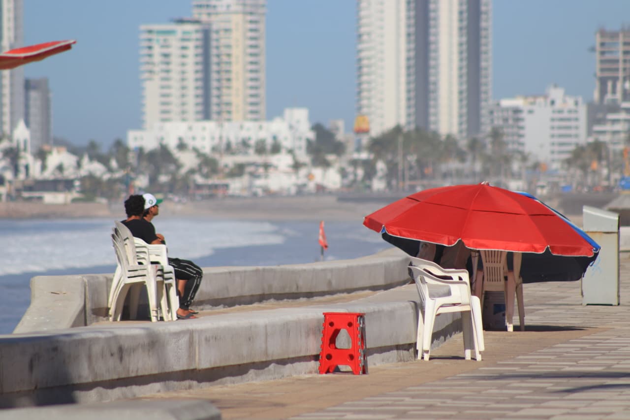Personas apartando su lugar en el malecón de Mazatlán.