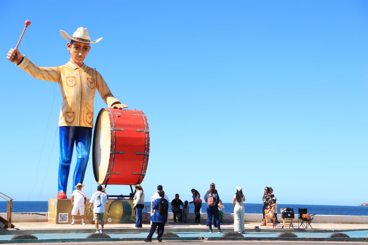 Personas apartando lugar en el malecón para el segundo desfile de Carnaval