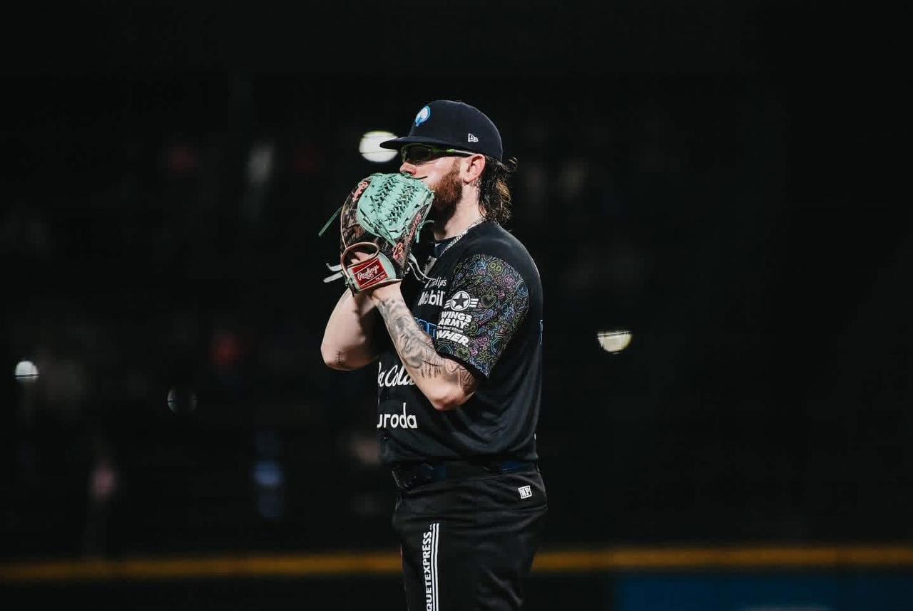 Pitcher con las manos a la altura de la cara, el guante tapándole la boca