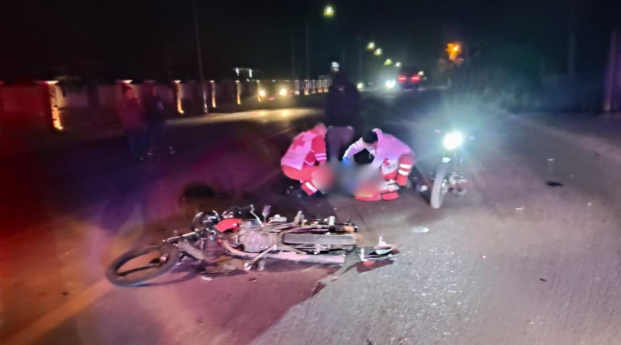 Motocicleta dañada en el piso y paramédicos de Cruz Roja atendiendo a un lesionado