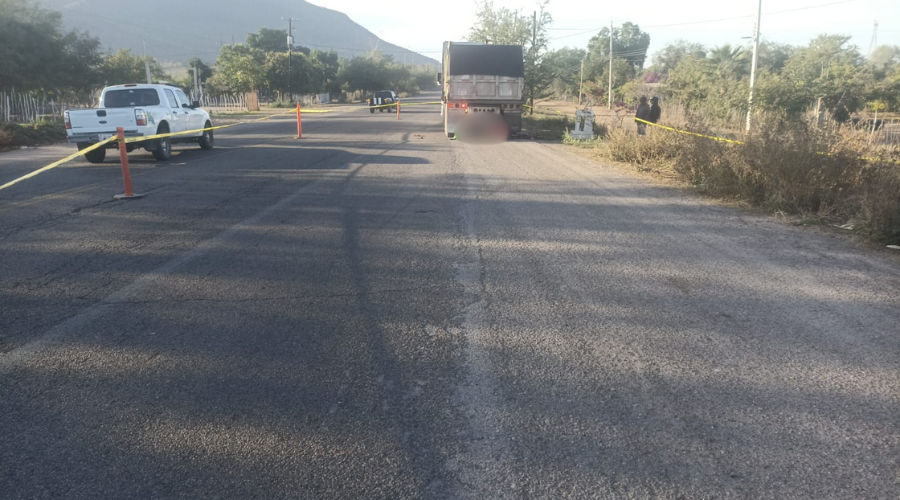 Carretera con una zona acordonada, donde está un tráiler estacionado y un difunto blureado