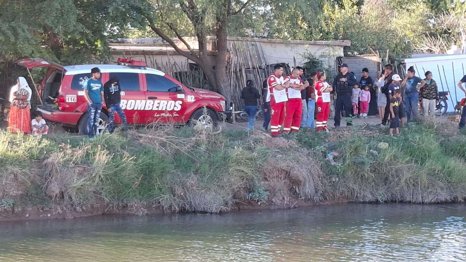 Elementos de rescate en la orilla de un canal realizando operativo