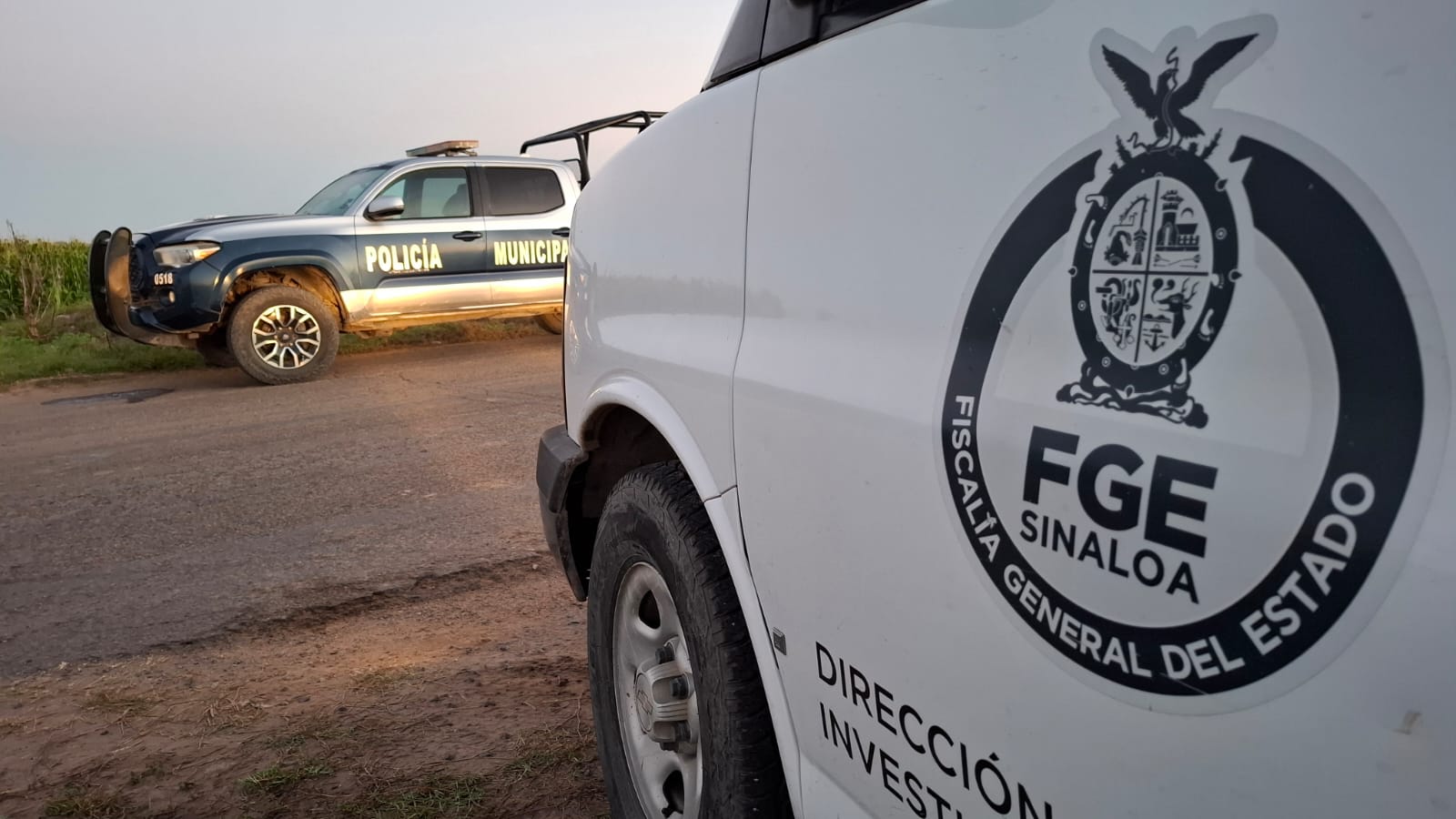 Patrulla de la Policía Municipal de Navolato al fondo. En primer plano, la unidad Semefo FGE