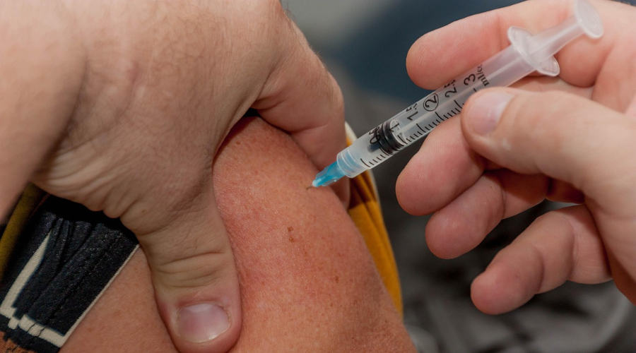 Medico aplicando vacuna a una persona