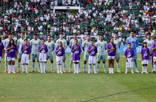 Equipo de la selcción mexicana formados detrás de equipo infantil femenino en estadio