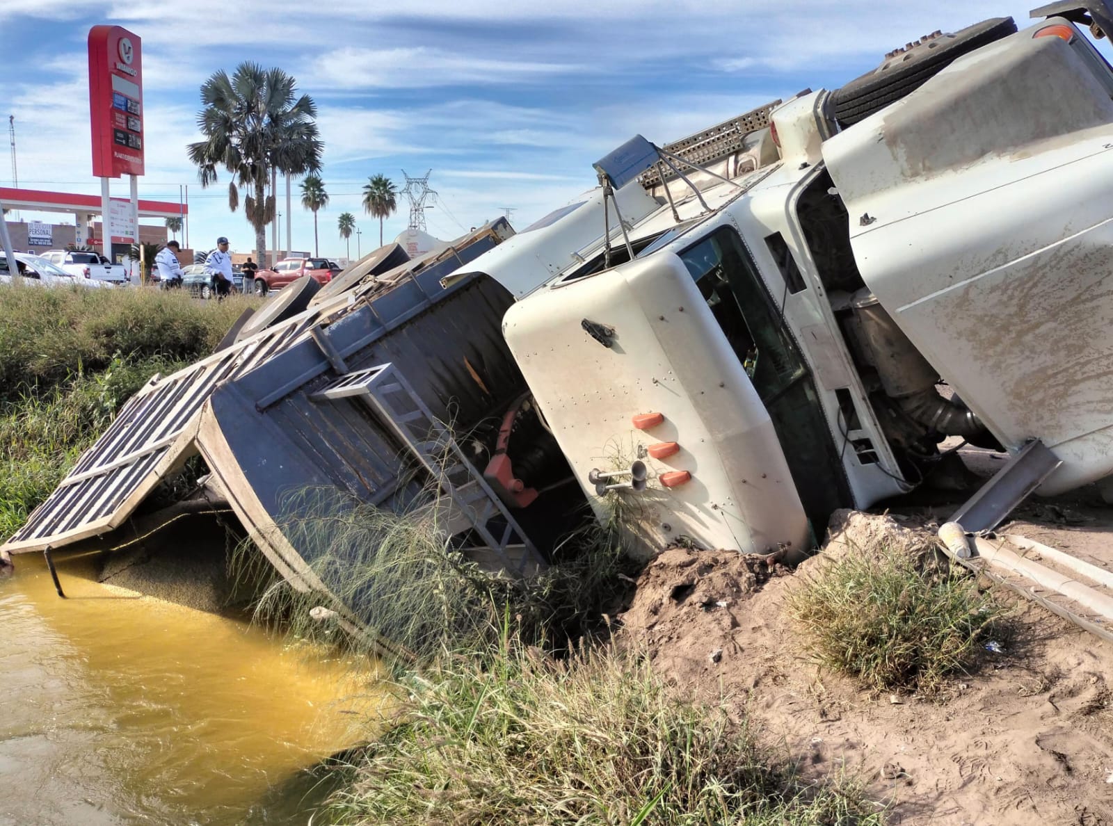 tractocamión volcado en un canal de riego