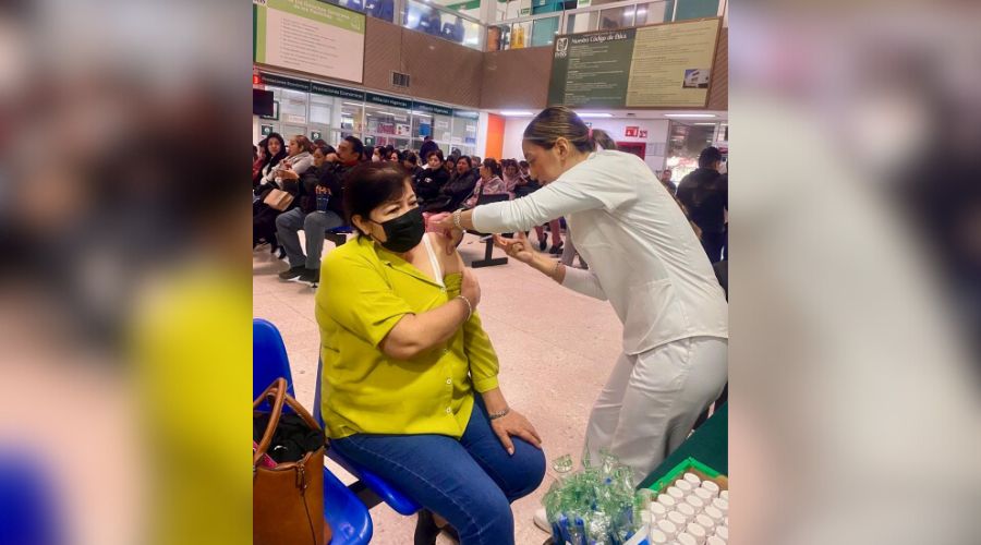 Enfermera aplicando una vacuna en el brazo de una mujer