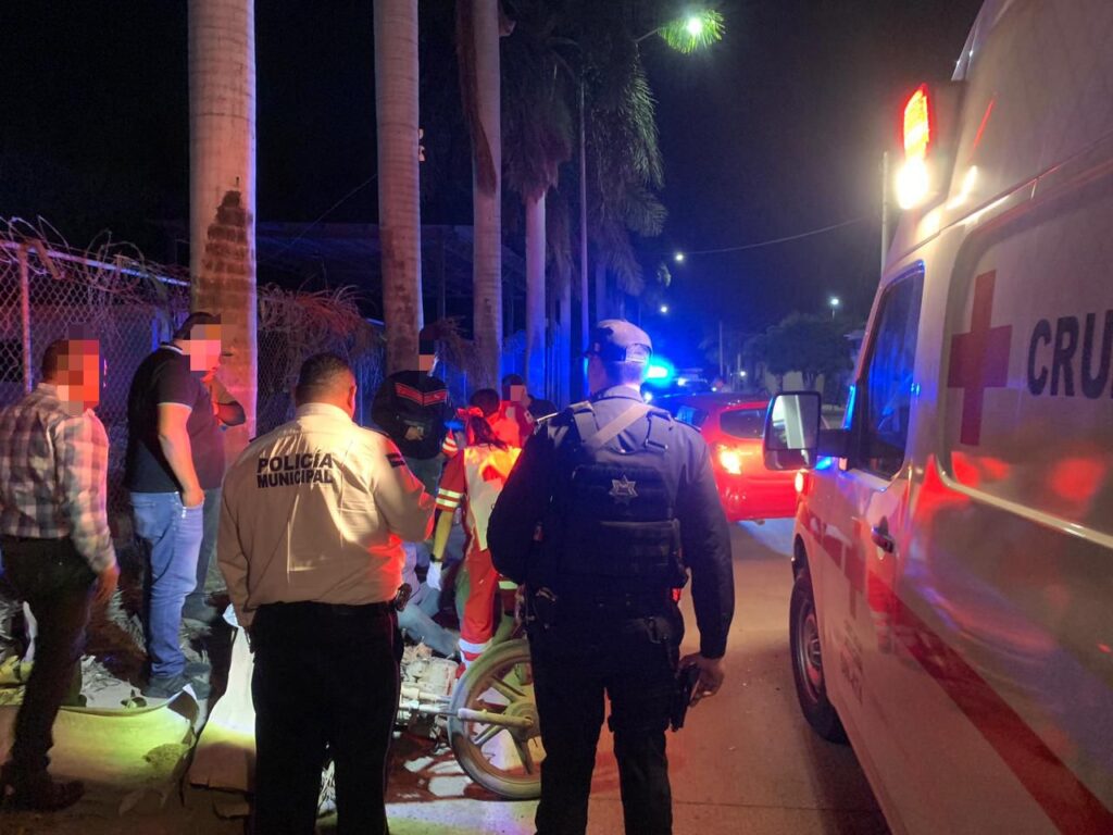 gente reunida en un accidente con una ambulancia y sirenas al fondo
