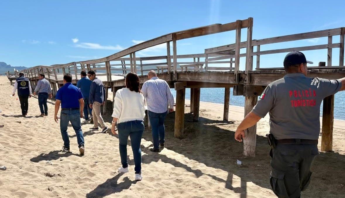 PErsonas caminando en la arena a lado del andador de el Maviri