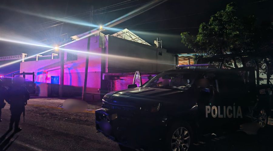 Unidad y elementos policiacos en una calle de noche