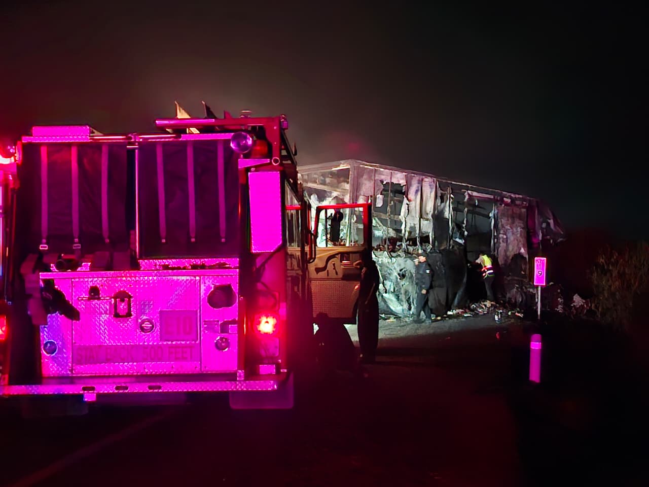 Unidad de bomberos y al fondo un trailer carbonizado