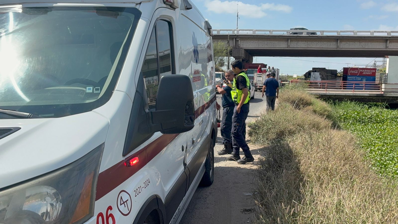 Ambulancia estacionada y paramédicos brindando apoyo