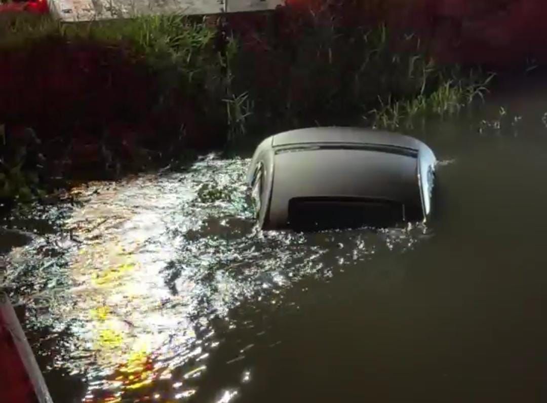 Automóvil dentro de canal con agua cubriéndolo