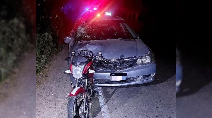 Carro y motocicleta en una calle y al fondo luces de patrulla