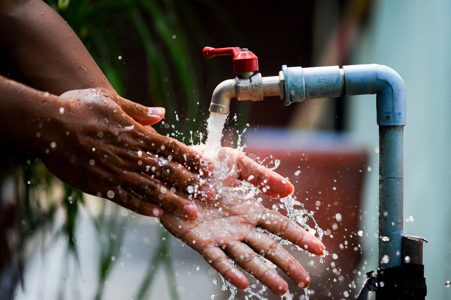 Persona lavándose las manos, llave donde sale agua