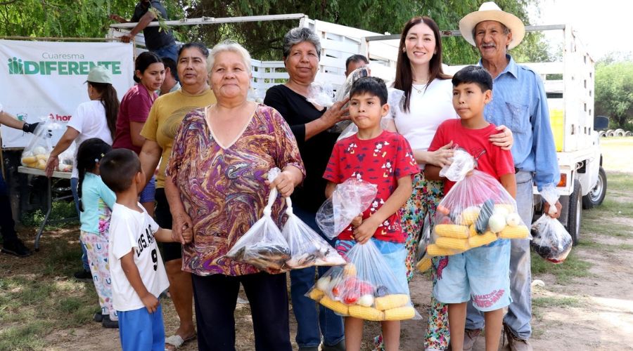 Personas, adultos y niños recibiendo apoyo de despensas y ropa por parte de DIF