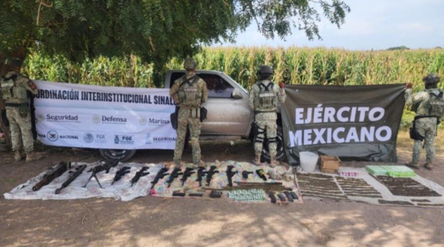 Elementos del Ejército Mexicano sosteniendo lonas con nombres y logos de corporaciones de segurad junyo a una camioneta al fondo y en la parte inferior una lona con armas y objetos asegurados