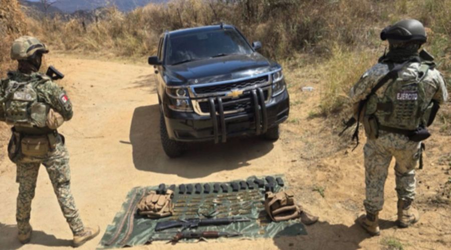 Elementos del Ejército Mexicano de espald, una camioneta de color negro y en el suelo una mnta oscura con objetos que fueron asegurados, en una zona de campo
