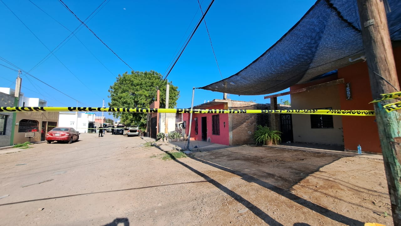 Cinta policial y al fondo viviendas y agentes policiacos