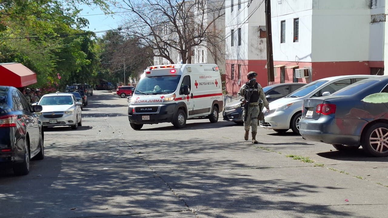 Ambulancia estacionada en mitad de la calle y un elemento del ejercito mexicano patrullando la zona