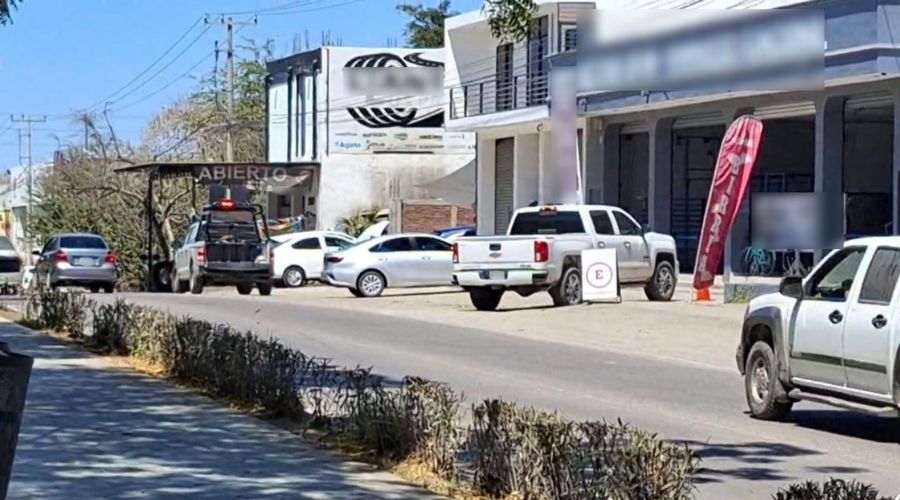 Calle con carros y establecimientos, se observa una patrulla
