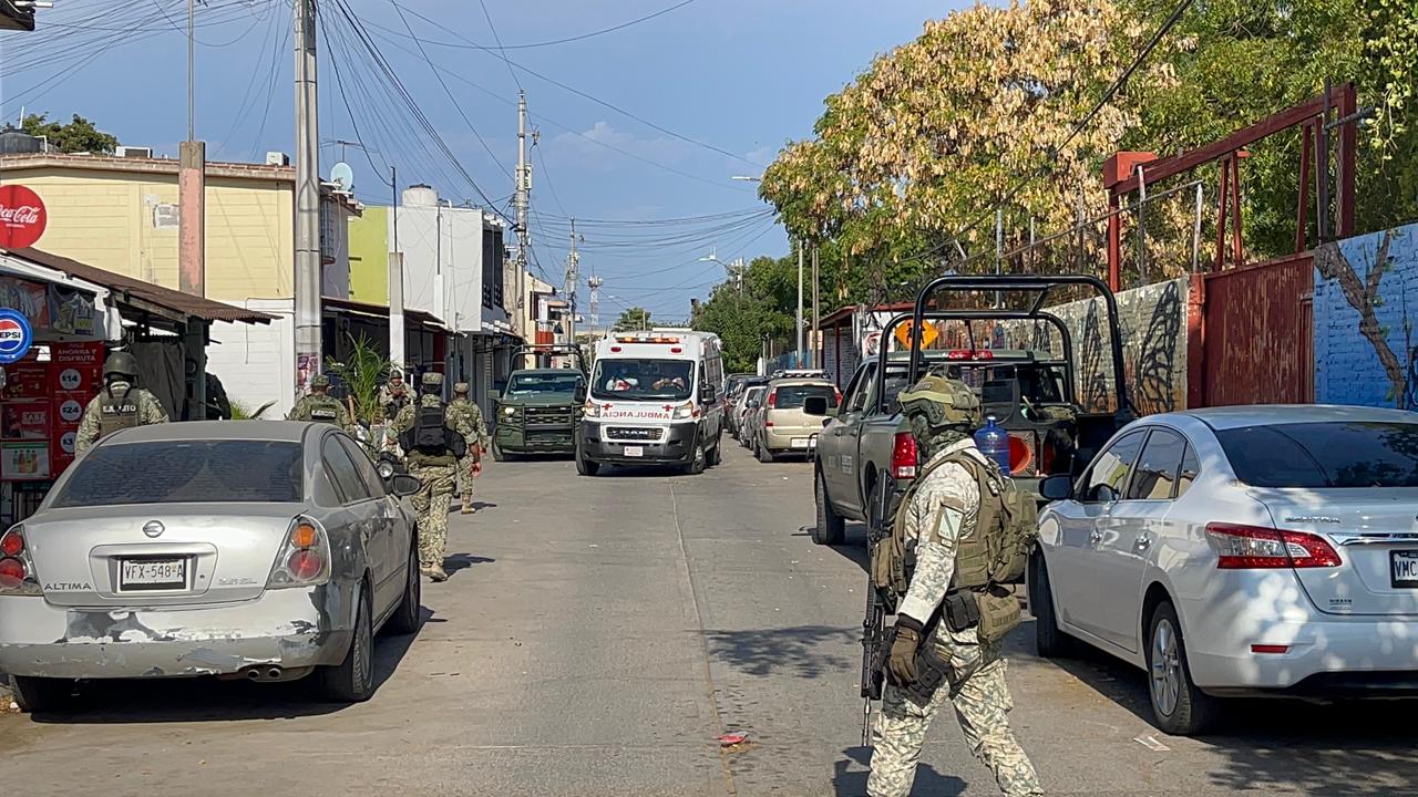 Elementos del ejercito mexicano en colonia asegurando la zona, al fondo ambulancia de la cruz roja