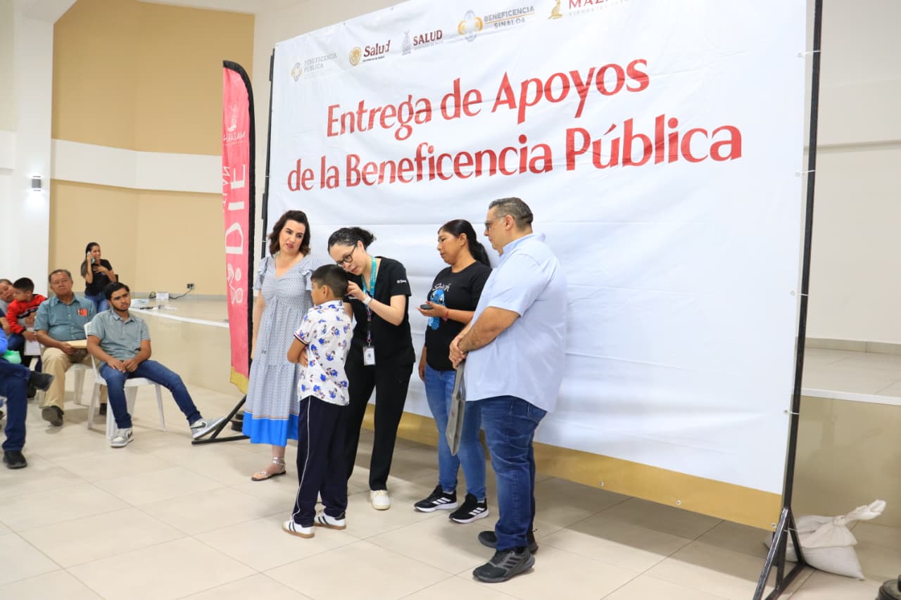 Autoridades de DIF Mazatlán y Beneficencia Pública de Sinaloa junto con una madre de familia haciendo entrega a un niño de un aparato de audición