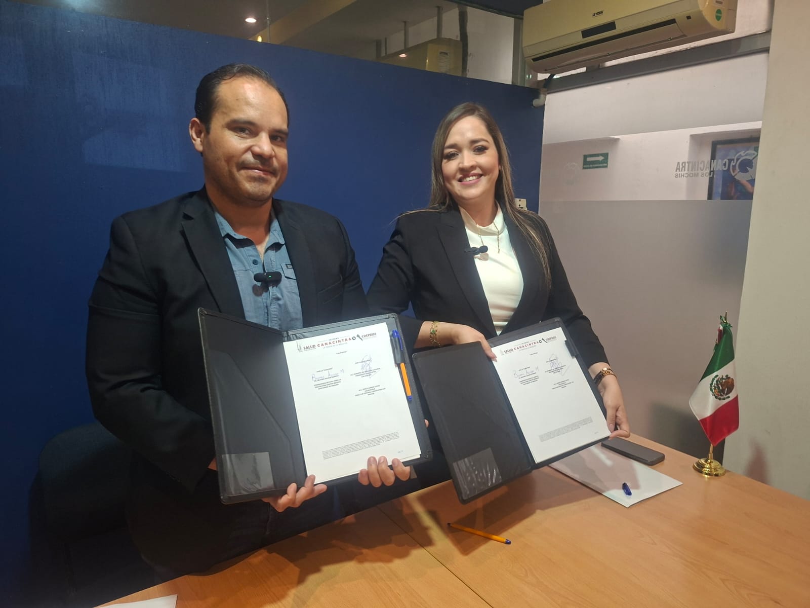 Personal de Canacintra Los Mochis y Coepris con documentos firmados posando para foto