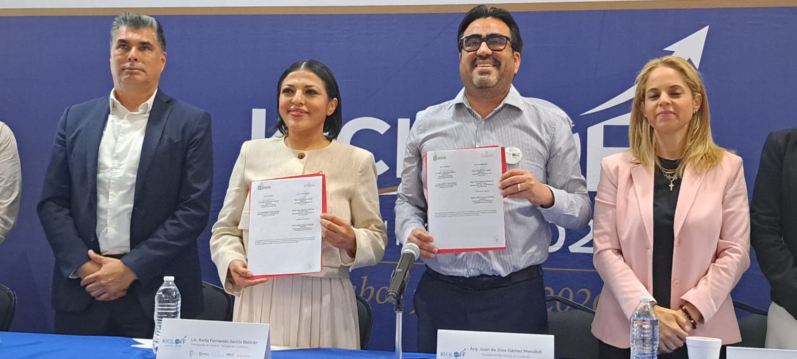 Personas junto al alcalde de Culiacáne n una rueda de prensa levantando unos documentos