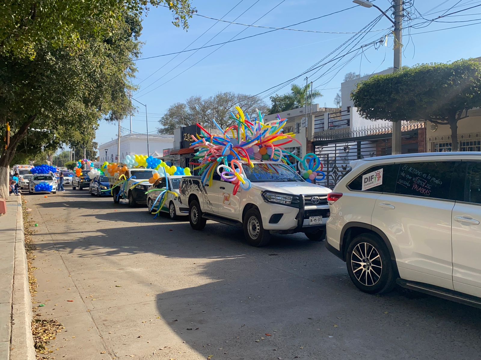 Carros con globos azueles en caravana