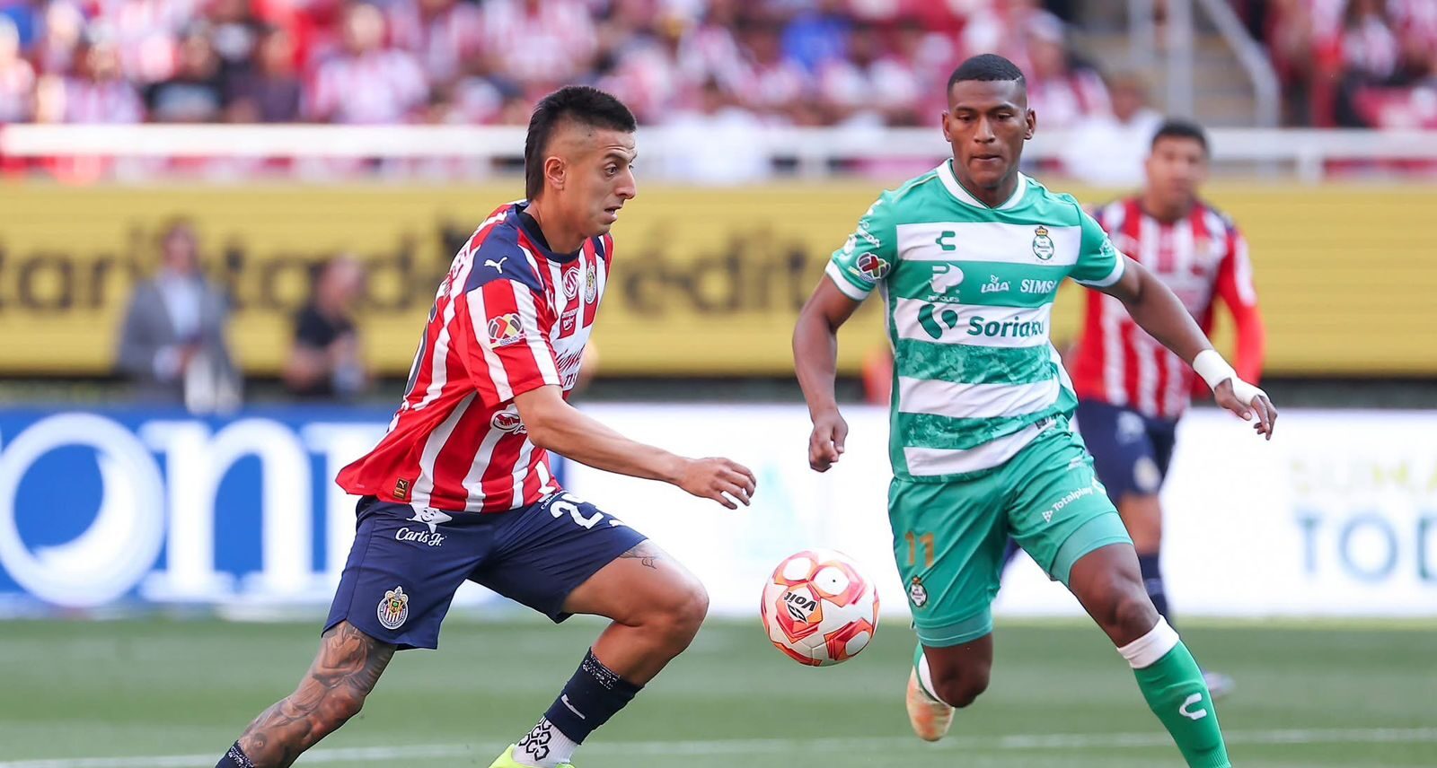 Roberto Alvarado junto a jugador de Santos en juego del Estadio Akron