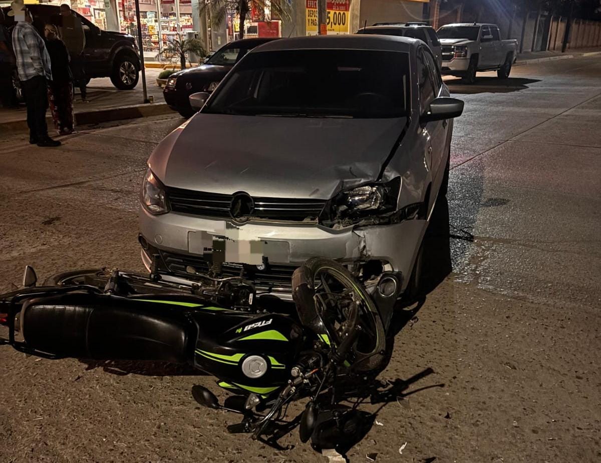 Carro sobre una motocicleta chocado con la motocicleta tirada