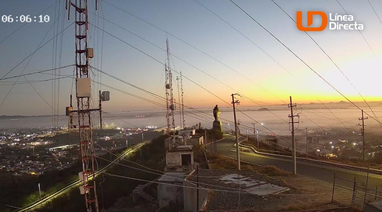 Captura de videograbación de la Virgen del valle de los Mochis en el Cerro de La Memoria, la ciudad se observa con bancos de niebla y el amanecer al fondo