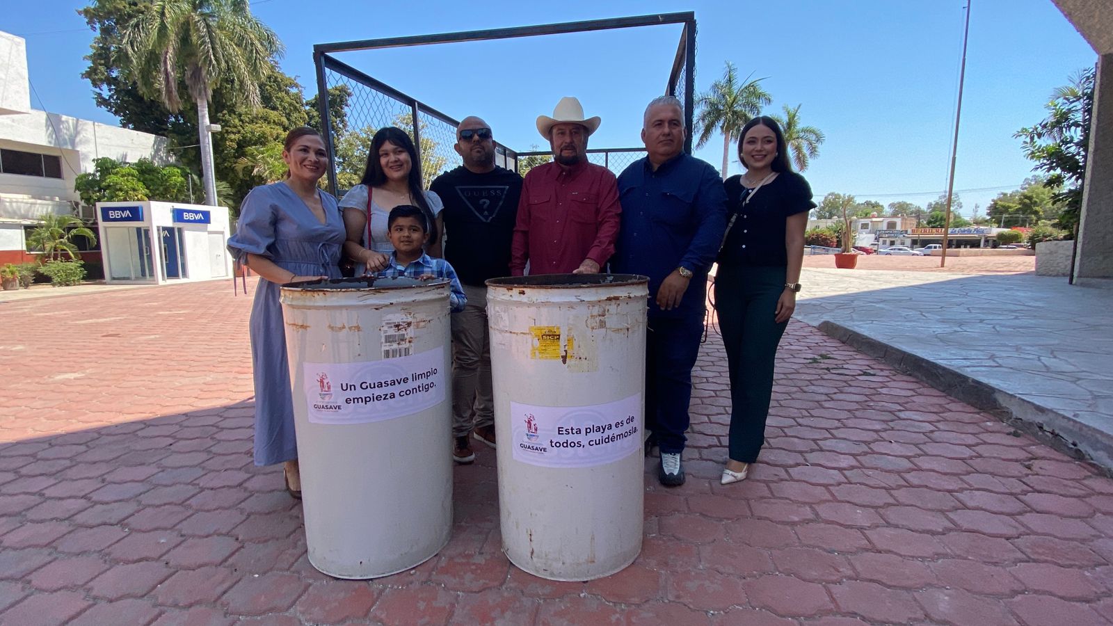Personas tomándose foto con botes de basura nuevos