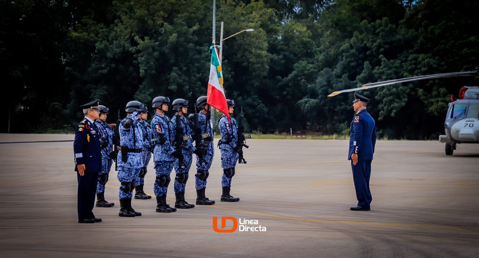 Edgar Campos frente a escolta de soldados con la bandera mexicana