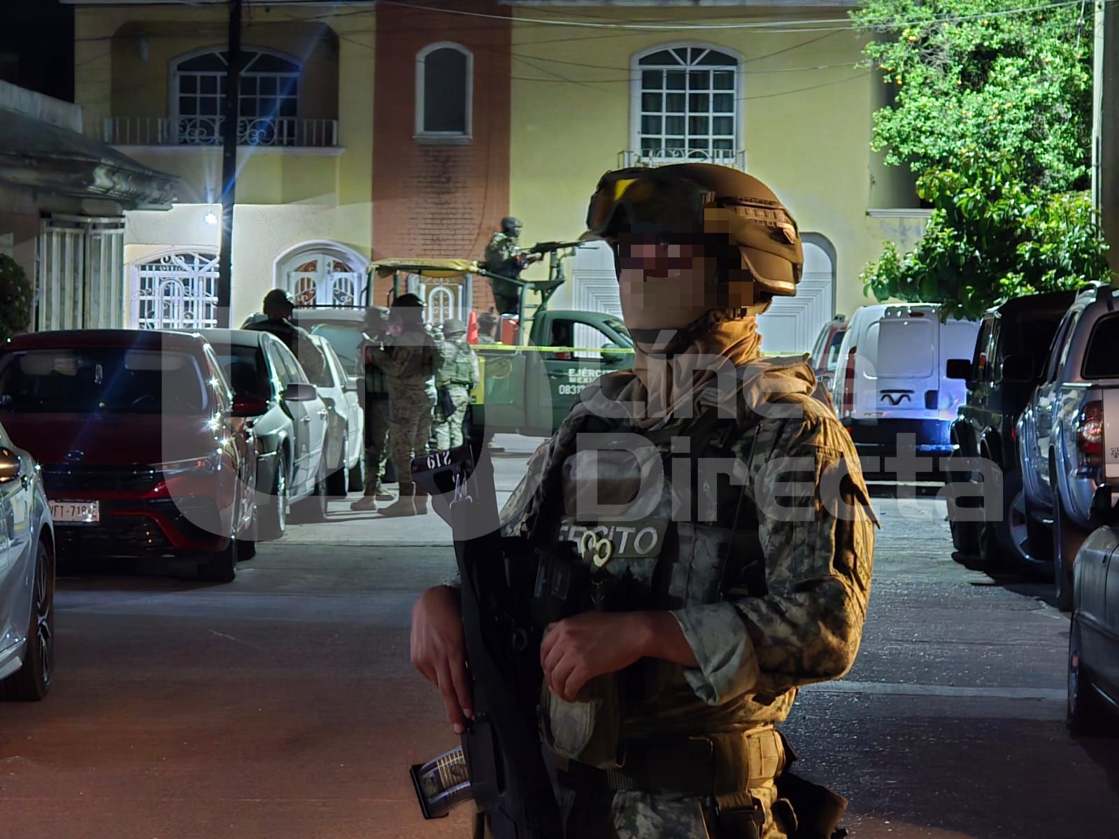 Elementos del Ejército Mexicano en una calle ente carros estacionados
