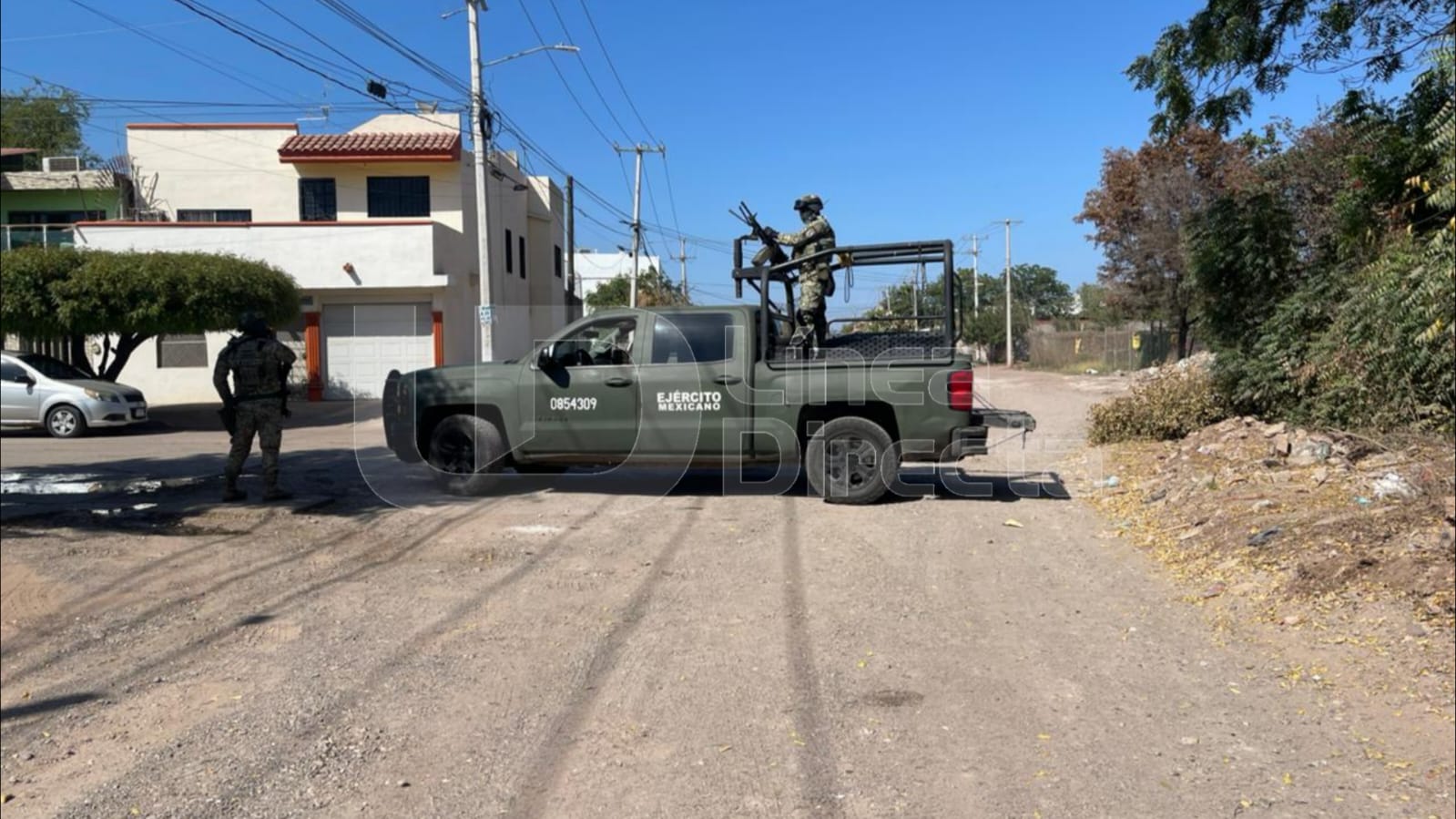 Unidad del Ejército Mexicano con elementos sobre la misma, en una calle