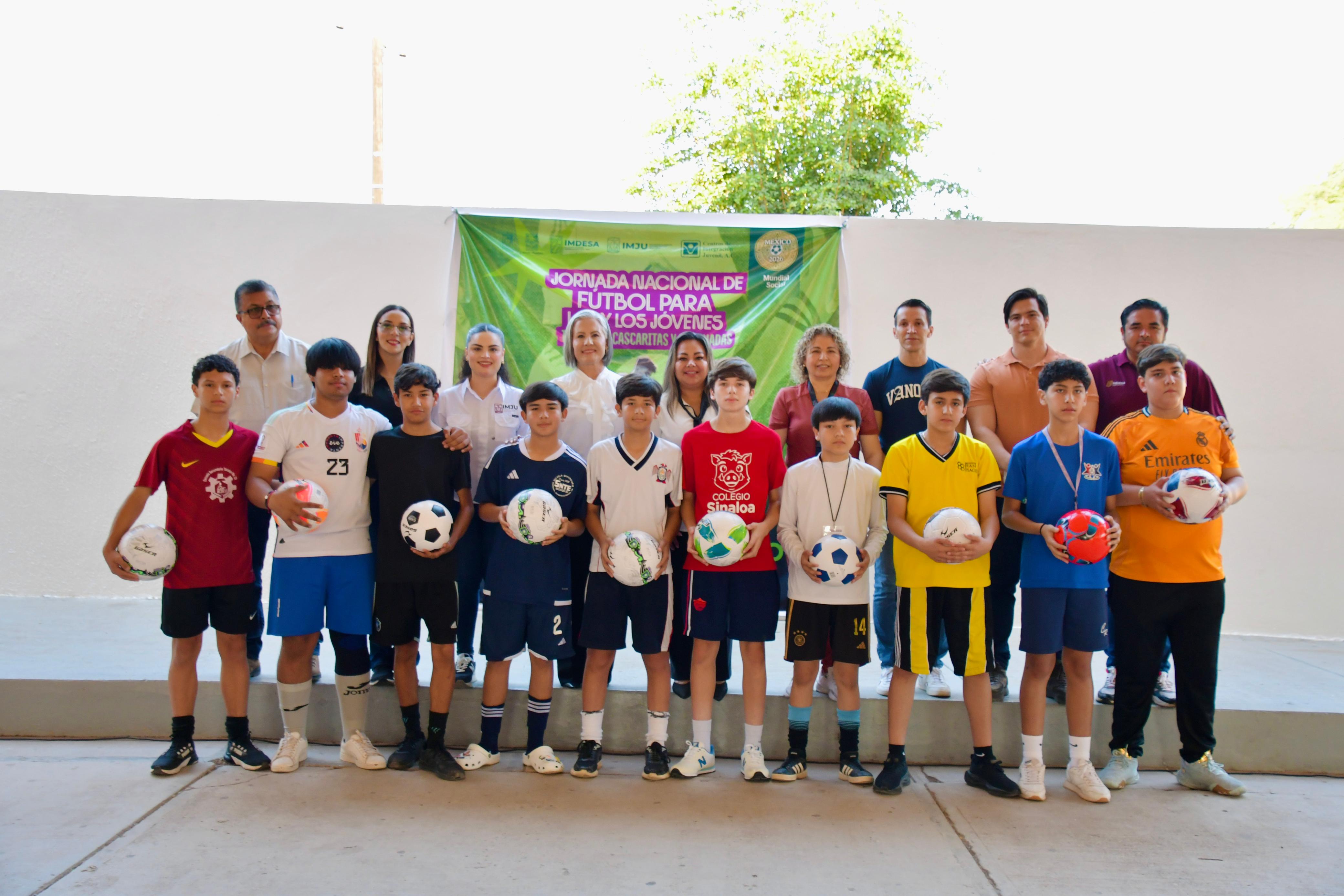 niños de equipo de futbol con balones en las manos