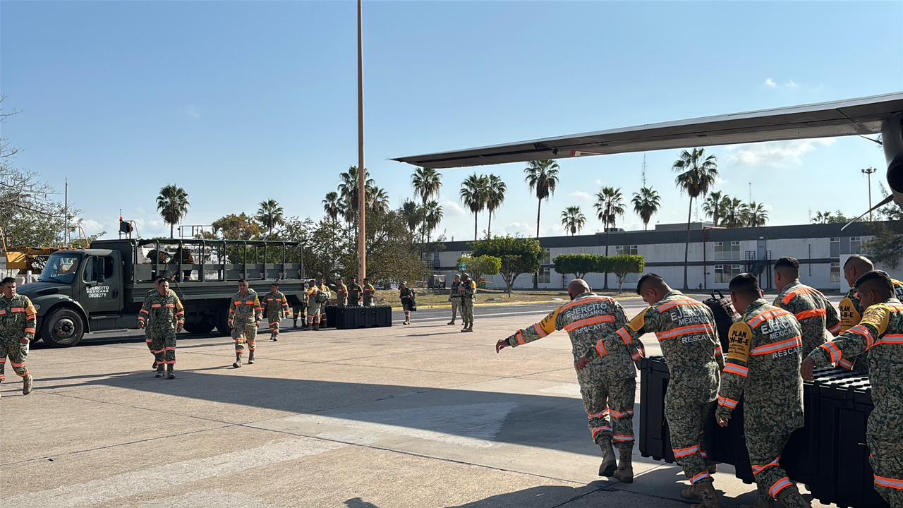 Militares junto a un avión junto a elementos de seguridad