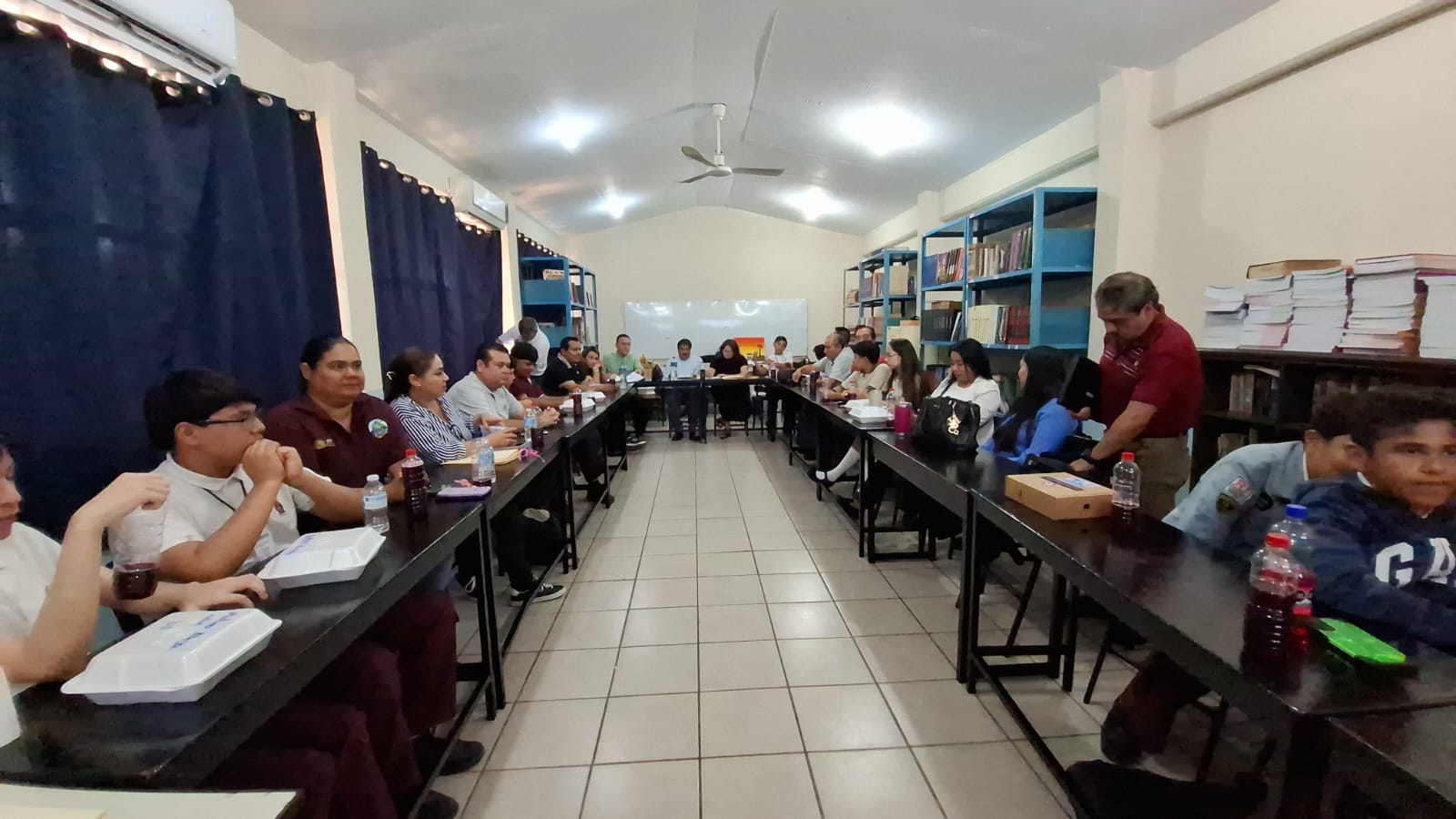 estudiantes sentados detrás de mesas en un aula de estudio