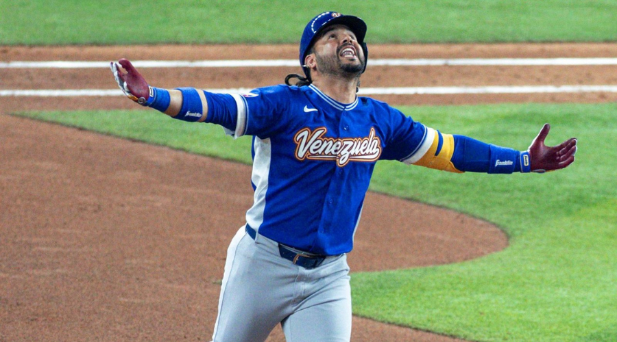 Jugador de beisbol corriendo las bases con los brazos extendidos y mirando hacía el cielo