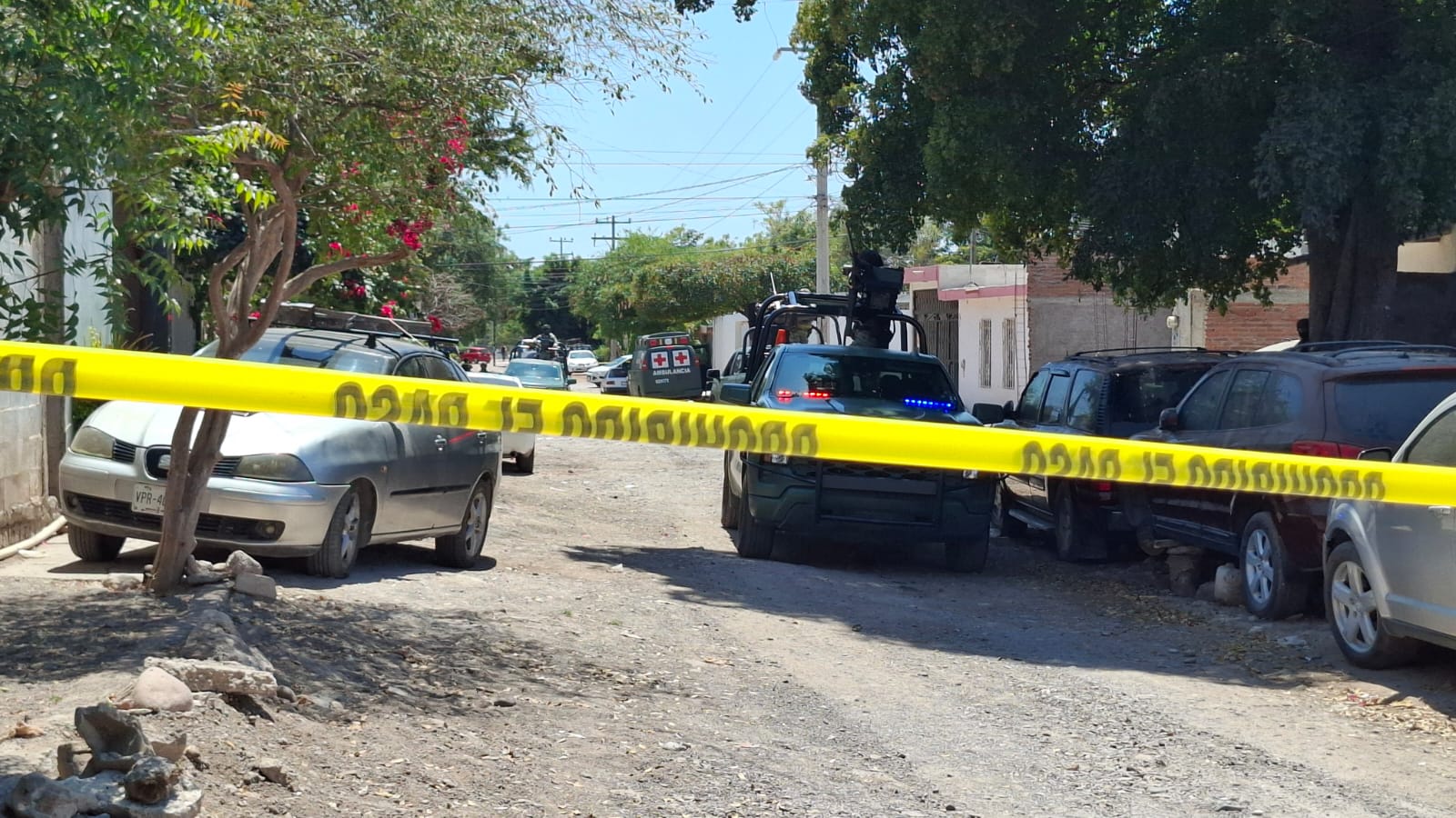 Zona acordonada con cinta amarilla y detrás patrullas policiacas