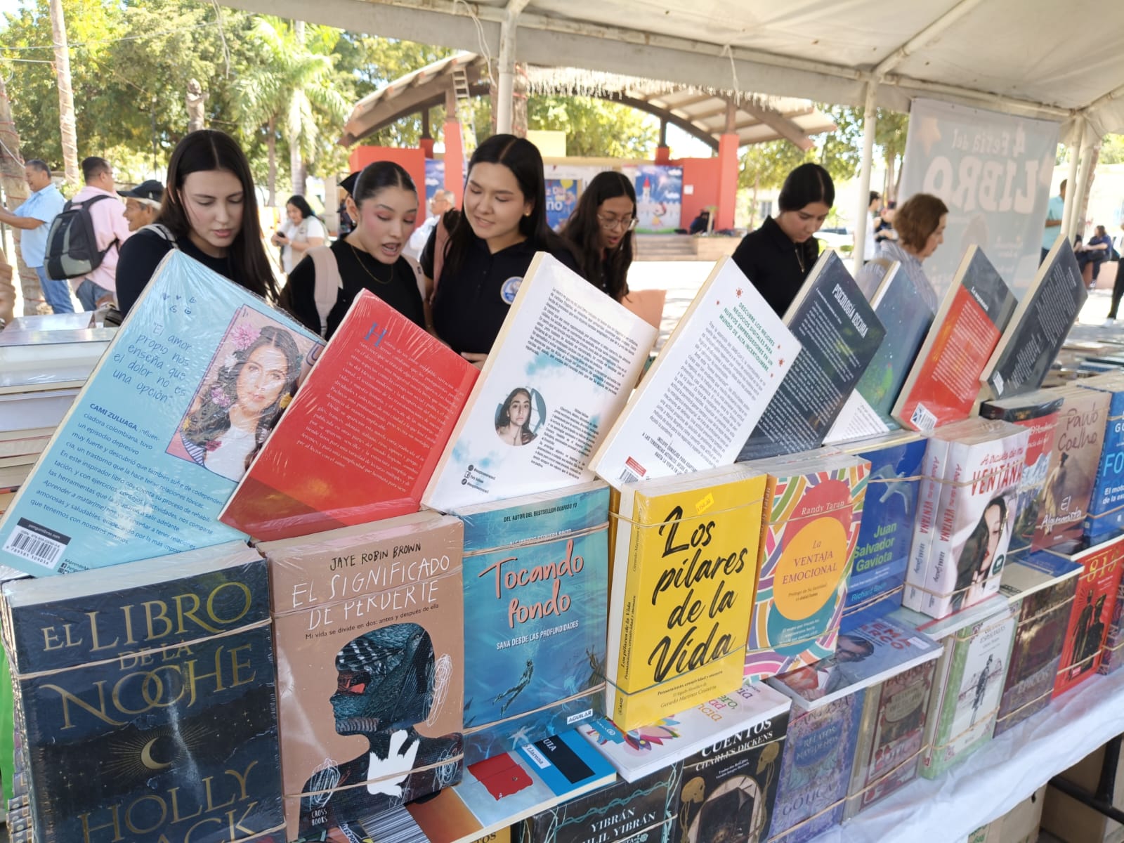 Libros en una mesa junto a estudiantes