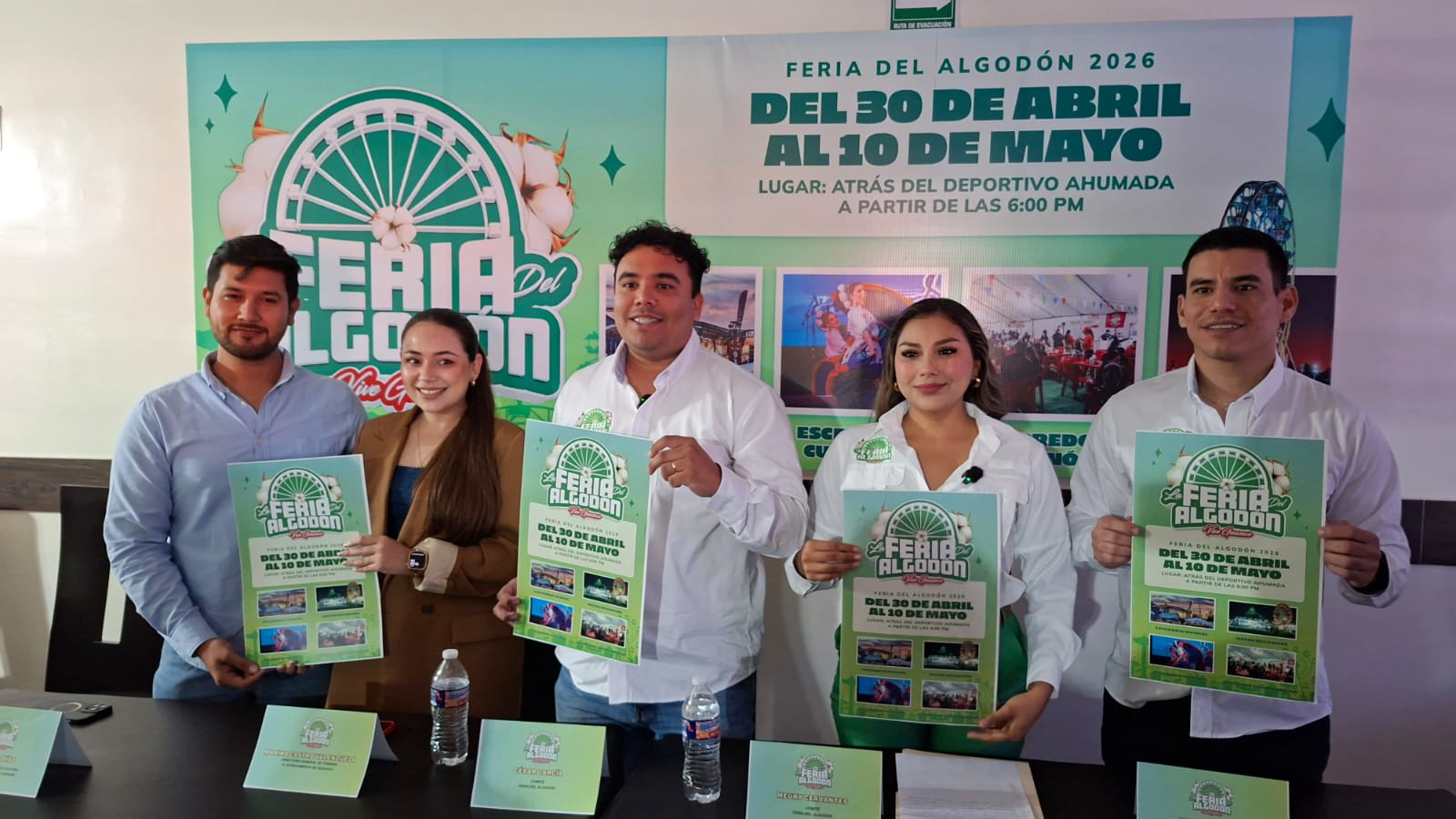 Personas sosteniendo cartel de invitación a la feria del algodón
